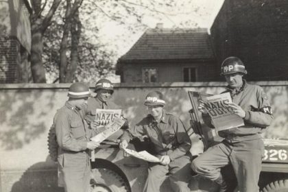 May 8. Four MPs take a break along a German road to read in the "Stars and Stripes" newspaper about the Nazi surrender. Credit: U.S.Army