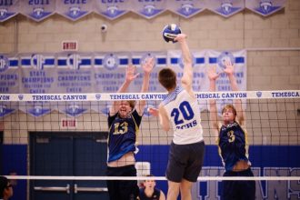 Temescal Canyon’s Caleb Peterson (#20) powers a hit past the reach of Santa Rosa Academy’s Sawyer Ross (#3) and another Ranger blocker. The Titans’ height at the net proved to be a deciding factor in their three-set victory.