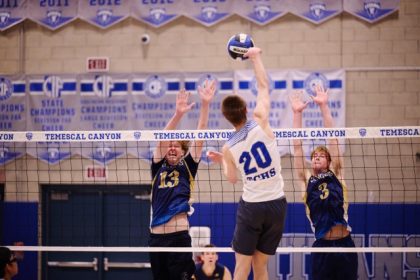 Temescal Canyon’s Caleb Peterson (#20) powers a hit past the reach of Santa Rosa Academy’s Sawyer Ross (#3) and another Ranger blocker. The Titans’ height at the net proved to be a deciding factor in their three-set victory.