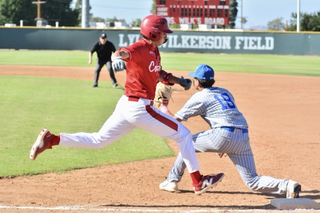 Corona’s Dylan Salcedo legs out an infield single while San Diego Eastlake’s Orozco (18) stretches for the throw during a State Regional playoff game.
