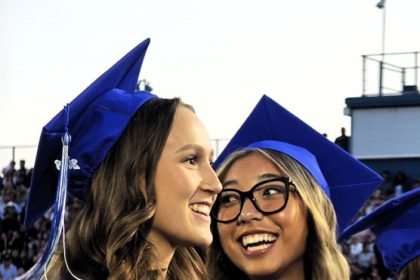 Maile Buckmiller (left) and Sinclair Smith (right) smile as they watch their Norco High Class of 2026 get their diplomas during the graduation ceremony.