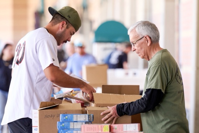 Lake Elsinore Storm Stadium. Lake Elsinore Storm player Kerrington Cross and a MilVet volunteer carefully sort and organize items destined for deployed troops' care packages.