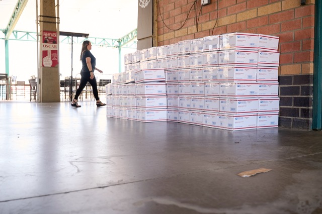 Mission accomplished: A massive wall of thousands of completed care packages stands ready for delivery at the conclusion of the MilVet packing event.