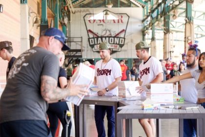 Lake Elsinore Storm players create an assembly-line and seal completed flat-rate care packages to be shipped out to military members serving overseas.