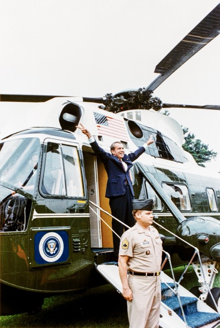 White House Helicopter. President Richard Nixon stands in front of the Sikorsky VH-3A "Sea King" slated for restoration, flashing peace signs, shortly before his resignation became effective, August 9, 1974. White House Photo Office
