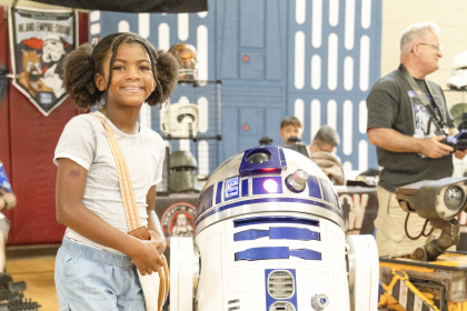 Alana Thomas meets R2D2 at the 4th annual Perris Comic Con Saturday, August 15, at the Bob Glass Gymnasium. The event included costumed attendees competing in a cosplay competition, a Magic the Gathering and Mario Kart Tournament, a performance from a Huntrix (K-Pop Demon Hunter) tribute group, and vendors.
