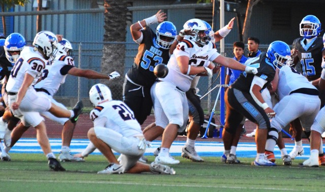 Eastvale Roosevelt’s Kaden Lovell (30) boots the extra point to tie the game at seven in the first quarter while Kaden Wayne (21) holds. Norco’s Justin Suliafu (53) tries to block the PAT while Derek DeSeife (64) blocks and Henderson Carter V (15) looks on