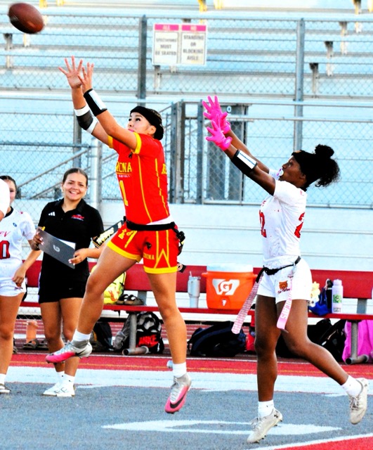 Corona’s Jaslene Negrette (1) leaps to haul in quarterback Arlene Cabrera’s pass while Redlands East Valley’s Kiorah Lui (22) reaches for an interception. The Nighthawks defeated the Panthers 31 – 6.