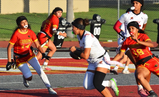 Corona’s Juliana Gonzalez (14) and Kanani Urquidez (18) chase Redlands East Valley quarterback Leylii Christensen (center). Jaslene Negrette (1) in the background eyes the action while covering a receiver.