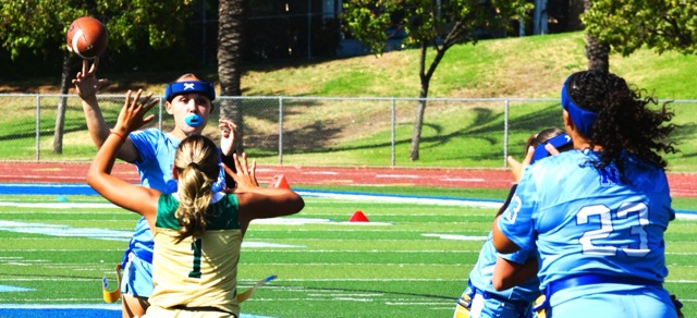 Norco Quarterback Jamie Martinez (left) tosses and extra point pass to Arianna Chaney (23) during the Cougars 41 – 0 thrashing of the Lakeside Lancers.