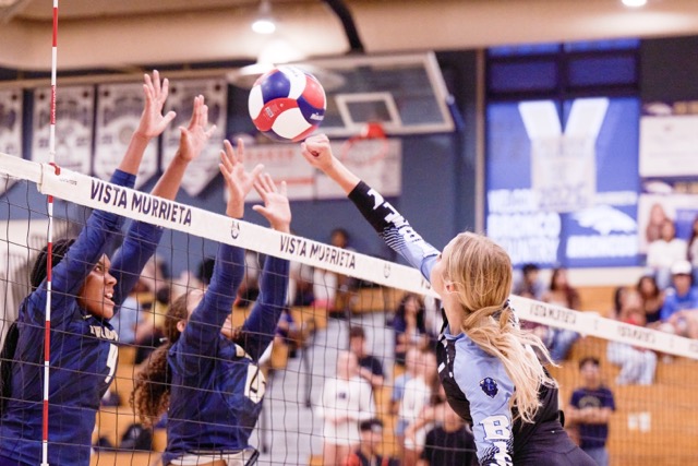 Liberty High School’s #1, Catalina Loven, attempts a spike over the net as two Vista Murrieta players defend