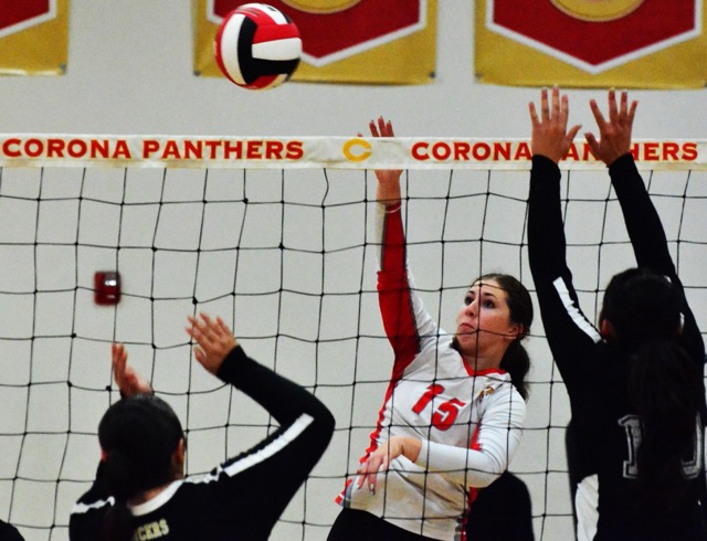 Corona’s Cora Jakubik (15) gets the ball over the net against two Lakeside defenders during the Panthers 3 – 0 win over the Lancers.