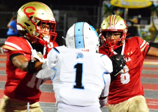 Corona’s Dominic Pickens (left) blocks San Gorgonio defender Nicholas Rodriguez (1) away from running back AJ Crompton.