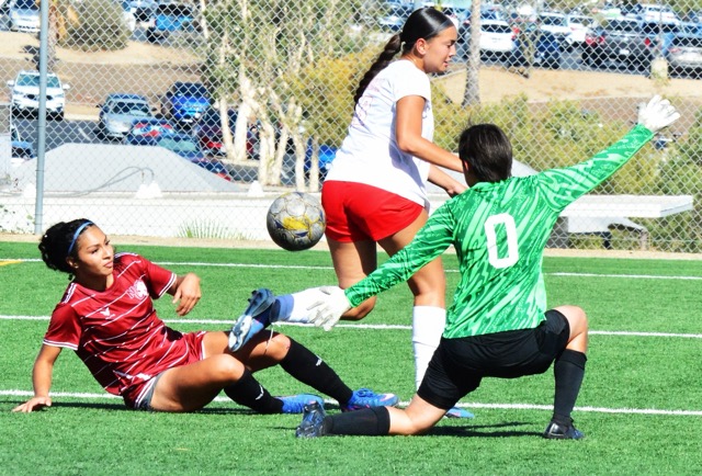 Norco College’s Naidelin Torres (left) has her shot on goal blocked by Palomar goalie Minha Moser (0) while defender Brooklyn McKinney (center) overruns the play.