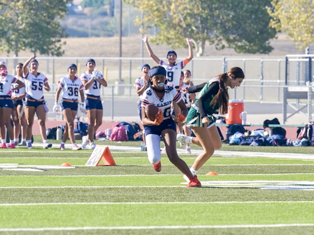 Roosevelt quarterback Peyton Wade (26) carries the ball as a Lakeside defender misses her flag.