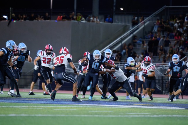 Liberty’s Isaac Ayala #10, fights through Elsinore defenders, breaking multiple tackle attempts for a moderate gain