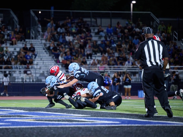 A Liberty ball carrier stretches the football across the goal line for a touchdown as Elsinore defenders attempt to bring him down
