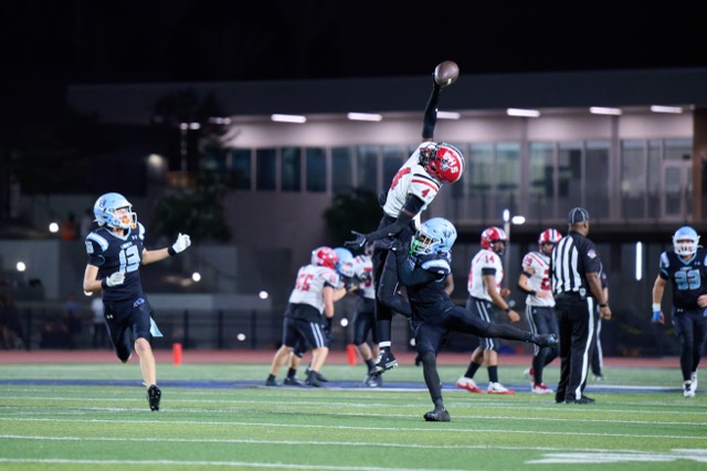 Elsinore’s Ledgend Johnson #4, reaches high for a pass over a Liberty defender as a fantastic catch just slips away from him