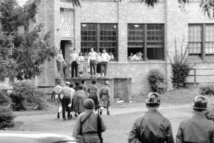 September 25. Seven of nine black students walk onto the campus of Central High School in Little Rock, Ark., with a National Guard officer as an escort as other troops watch.  Credit: AP Photo