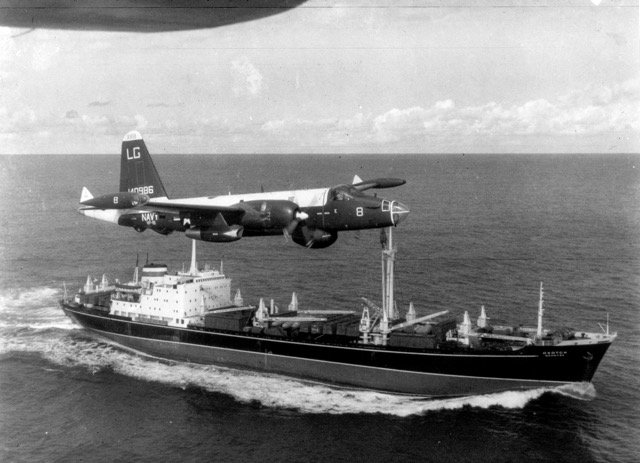 October 16. A US Navy P-2H Neptune of VP-18 flying over a Soviet cargo ship with crated Il-28 Bombers on deck during the Cuban Crisis. Credit: USN