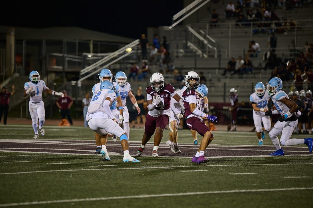 Paloma Valley’s, Damon Rowe #4, makes a catch over the middle, breaks a Liberty tackle, and gains several more yards before being brought down.