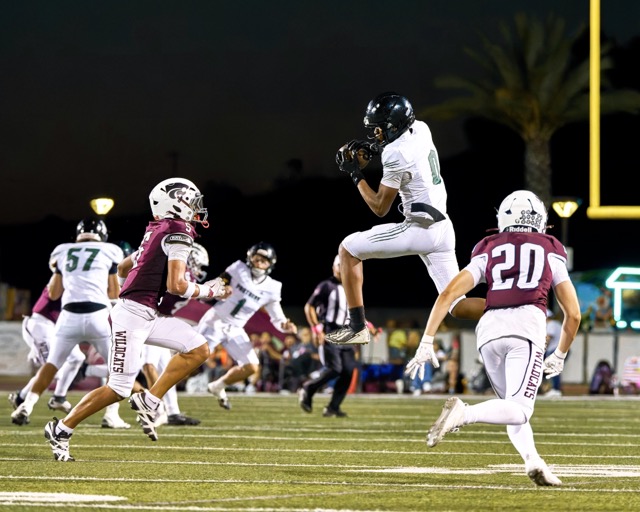 Perris’s Jordan Johnson (#0) secures a pass as Paloma Valley’s Antonio Castellon (#20) sizes up the tackle
