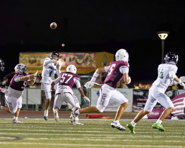 Perris’s Quarterback Corbin Kemp (#1)manages to get the pass off with a Paloma Valley Neeko Scott (#57) closing in.