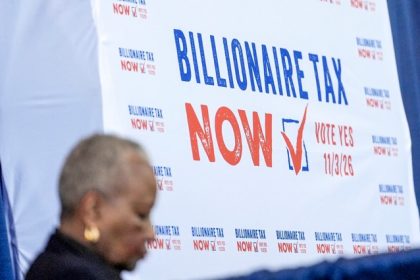 A sign displayed at the Billionaire Tax Now booth at the 2026 California Democratic Party State Convention in San Francisco on Feb. 21, 2026.  Credit: Photo by Jeff Chiu, AP Photo