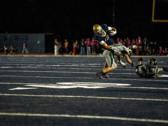Vista Murrieta’s, Kellen Guinn (13), hauls in the pass and turns upfield before a big hit from a Murrieta Mesa defender.
